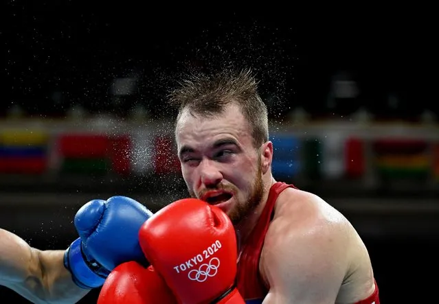 Uzbekistan's Fanat Kakhramonov (red) takes a punch from Kazakhstan's Abilkhan Amankul during their men's middle (69-75kg) preliminaries round of 16 boxing match during the Tokyo 2020 Olympic Games at the Kokugikan Arena in Tokyo on July 29, 2021. (Photo by Luis Robayo/Pool via Reuters)