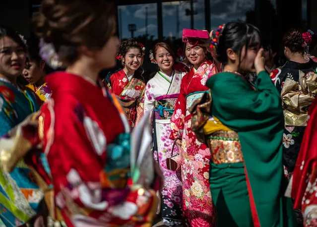 Women in colourful Okinawan kimonos arrive to attend a ceremony on Coming of Age Day on January 13, 2019 in Okinawa City, Japan. Coming of Age Day is a Japanese holiday held every January to celebrate people who have reached 20 – the official age of adulthood in Japan. Despite being a solemn affair in some parts of Japan, Okinawans have become known for their flamboyant and occasionally boisterous celebrations. (Photo by Carl Court/Getty Images)