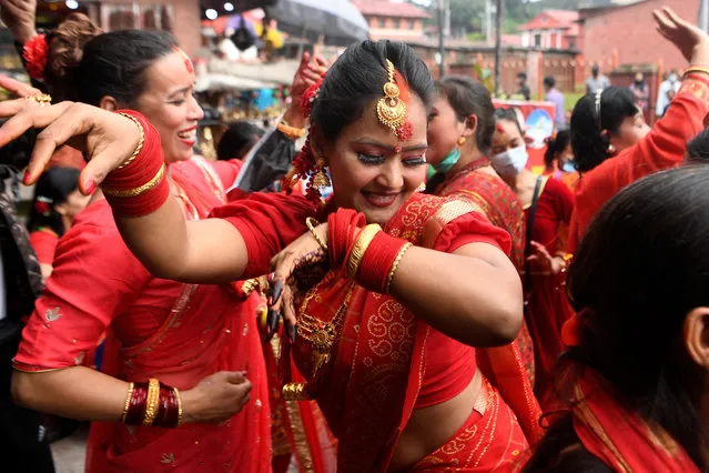 Hindu women dance after paying homage to Shiva, the Hindu god of destruction, as they celebrate the Teej festival outside the Pashupatinath temple, which is closed due to Covid-19 coronavirus pandemic, in Kathmandu on September 9, 2021. (Photo by Prakash Mathema/AFP Photo)