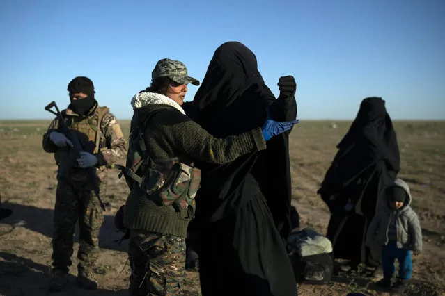 A woman is frisked by a U.S.-backed Syrian Democratic Forces (SDF) fighter at a screening area after being evacuated out of the last territory held by Islamic State militants, in the desert outside Baghouz, Syria, Friday, March 1, 2019. (Photo by Felipe Dana/AP Photo)