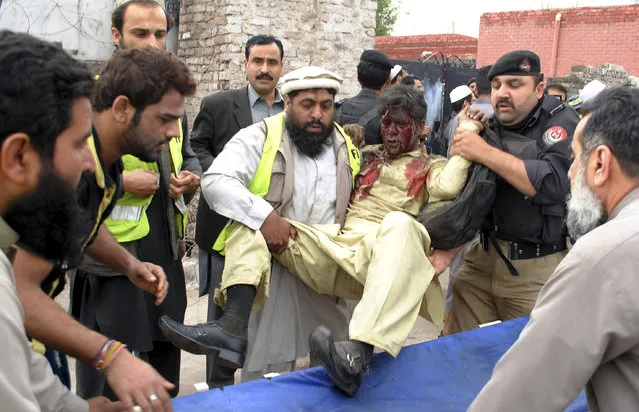 Pakistani volunteers carry an injured passenger following a bomb blast in Peshawar, Pakistan, Wednesday, March 16, 2016. A bomb ripped through a bus carrying Pakistani government employees in the northwestern city of Peshawar on Wednesday, killing a number of people, police said. (Photo by Mohammad Sajjad/AP Photo)