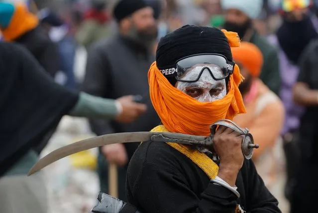 A Nihang or Sikh warrior holds a sword during a protest, as farmers march towards New Delhi to press for better crop prices promised to them in 2021, at Shambhu barrier, a border crossing between Punjab and Haryana states, India on February 21, 2024. (Photo by Adnan Abidi/Reuters)
