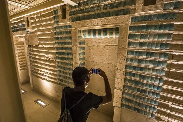 A visitor takes a photo of a relief depicting the third dynasty Ancient Egyptian Pharaoh Djoser (27th century BC), surrounded by hieroglyphs showing his regnal names, at the newly-restored southern cemetery in the Saqqara Necropolis south of Egypt's capital Cairo on September 14, 2021. (Photo by Khaled Desouki/AFP Photo)