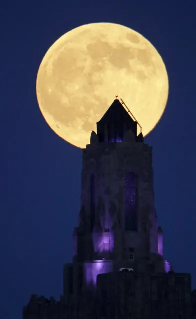 A full moon rises beyond the Power and Light building Saturday, July 8, 2017, in downtown Kansas City, Mo. (Photo by Charlie Riedel/AP Photo)