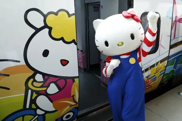 A performer dressed as a Hello Kitty poses next to Hello Kitty-themed Taroko Express train in Taipei, Taiwan March 21, 2016. The train will make its inaugural run on a round trip from Taipei to Taitung on Monday, according to the Taiwan Railways Administration (TRA). (Photo by Tyrone Siu/Reuters)