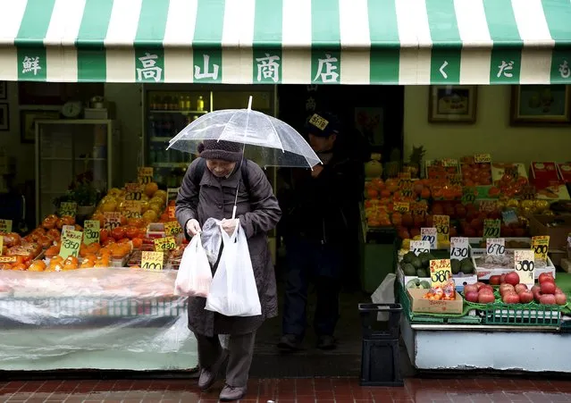 A shopper holding plastic bags walks out from a greengrocer's at Tokyo's Sugamo district, an area popular with the Japanese elderly, in Tokyo, Japan, March 14, 2016. (Photo by Yuya Shino/Reuters)