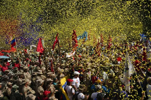 Confetti showers Bolivarian Militia members and government supporters at a march commemorating a 2004 speech by late President Hugo Chavez that is considered by his supporters a key anti-imperialist moment in the history of his Bolivarian Revolution in Caracas, Thursday, February 29, 2024. (Photo by Ariana Cubillos/AP Photo)