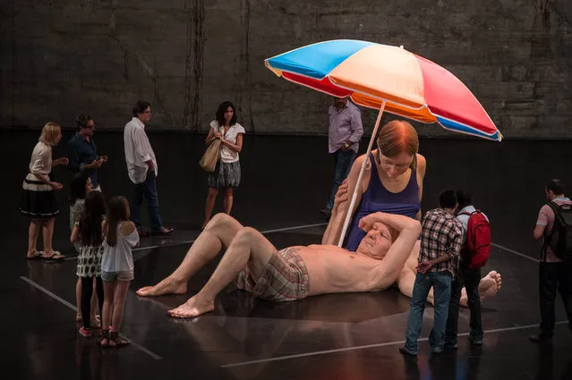 The sculpture titled “Couple under an Umbrella” by Australian artist Ron Mueck is displayed at the Museum of Modern Art (MAM) in Rio de Janeiro, Brazil, on March 19, 2014. The exhibition is displaying 9 sculptures for the first time in Brazil until June 1, 2014. (Photo by Yasuyoshi Chiba/AFP Photo)