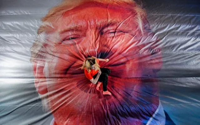 Festival volunteer Aisling Wilson jumps into the Jump Trump art installation created by artists Erik Kessels and Thomas Mailaender, which is on display at the Golden Thread Gallery in Belfast as part of the 2019 Belfast Photo Festival on June 6, 2019. The exhibition includes the Jump Trump installation on display for the first time in the UK and Ireland. (Photo by Justin Kernoghan/PA Images via Getty Images)