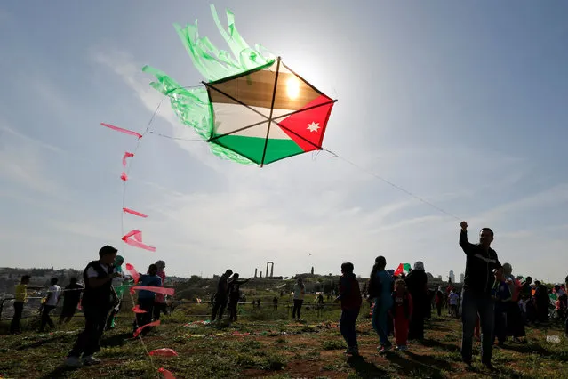 People fly kites decorated with the Jordanian national flag during an event celebrating spring at the Citadel in Amman, Jordan, April 15, 2016. (Photo by Muhammad Hamed/Reuters)