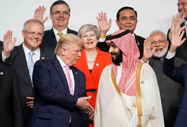 U.S. President Donald Trump shakes hands with Saudi Arabia's Crown Prince Mohammed bin Salman during family photo session with other leaders and attendees at the G20 leaders summit in Osaka, Japan, June 28, 2019. (Photo by Kevin Lamarque/Reuters)