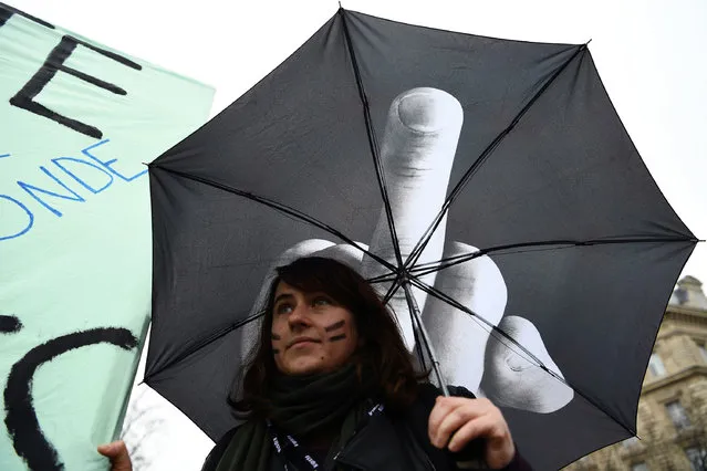 A woman holds an umbrella during a demonstration for the International Women's Day in Paris on March 8, 2017. (Photo by Gabriel Bouys/AFP Photo)