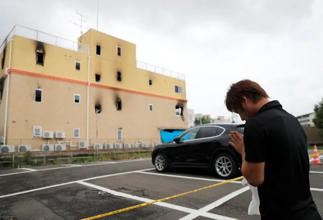 A man prays for the victims of the arson attack in front of the torched Kyoto Animation building n Kyoto, Japan, July 19, 2019. On the morning of 18th, a fire occurred with an explosion sound at a studio of an animation production company “Kyoto Animation” in Fushimi Ward, Kyoto City. 34 staffs died, and 34 staffs were injured as of 19th. Shinji Aoba, the 41-year-old man who allegedly splashed gasoline in the building while screaming “Die!” reportedly said. “They stole my idea” when he was taken by police. Kyoto Animation produced poplar animations such as “K-On!”, “The Melancholy of Haruhi Suzumiya” and “Sound! Euphonium”. (Photo by Kim Kyung-Hoon/Reuters)