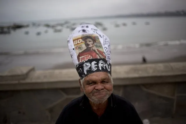 Carlos Humala poses for the picture wearing a makeshift hat resembling the Pope's, with a picture of soccer player Paolo Guerrero, during Saint Peter's day celebrations in Lima, Peru, Monday, June 29, 2015. (Photo by Rodrigo Abd/AP Photo)