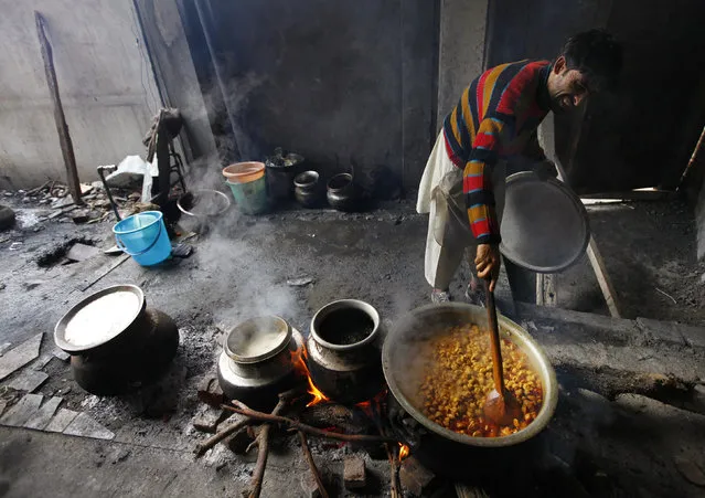 A worker prepares food in a community kitchen set up by a local Muslim charity which is being distributed for free to a nearby hospital in Srinagar August 10, 2010. (Photo by Reinhard Krause/Reuters)