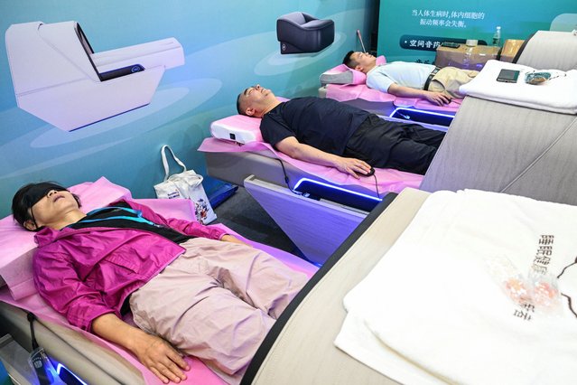 People take a rest as they check a sleep cabin during the International Exhibition of Senior Care, Rehabilitation Medicine and Healthcare (CHINA AID 2024) at the Shanghai New International Expo Centre (SNIEC) in Pudong district of Shanghai on June 13, 2024. (Photo by Héctor Retamal/AFP Photo)