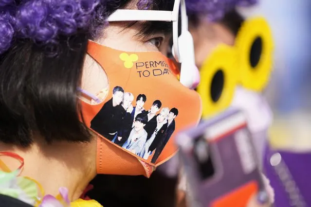 A fan of South Korean K-pop band BTS wears a face mask with a photo of BTS upon their arrival for the concert “BTS Permission to dance on stage-Seoul” at Seoul Olympic stadium in Seoul, South Korea, Thursday, March 10, 2022. (Photo by Lee Jin-man/AP Photo)