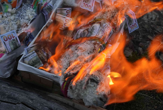 An offering of a dried baby llama and fake U.S. burn in honor of Pachamama, or Mother Earth, during a New Year ritual on Turriturrini Mountain on the outskirts of Huarina, Bolivia, Friday, June 21, 2024. Aymara Indigenous communities are celebrating the Andean New Year 5,532 or “Willka Kuti” which translates to “Return of the sun” in Aymara. (Photo by Juan Karita/AP Photo)