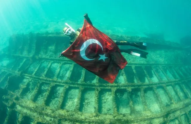 Record holder freediver Birgul Erken swims with Turkish flag above the 70-meters British shipwreck “SS Milo” at historical Gallipoli Peninsula as part of the 18th March Martyrs' Memorial Day and the 107th anniversary of Canakkale Naval Victory in Canakkale, Turkiye on March 13, 2022. (Photo by Mahmut Serdar Alakus/Anadolu Agency via Getty Images)