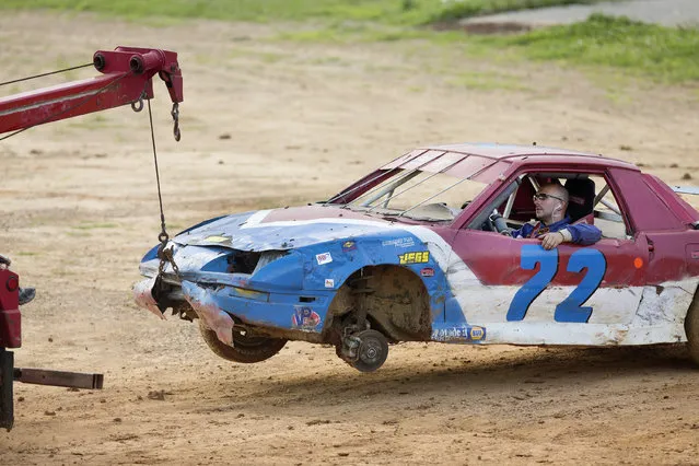 In this July 17, 2015 photo, Keith Gipson is towed off the track after a wheel broke loose from his car during dirt track racing at the Ponderosa Speedway in Junction City, Ky. Gipson lost his wheel in a qualifying round and could not get it repaired in time to race again that night. (Photo by David Stephenson/AP Photo)