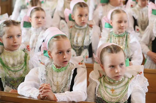 Girls wearing traditional Sorbian festive dress arrive back in church to continue mass following the annual Sorbian Corpus Christi procession on May 26, 2016 in Crostwitz, Germany. Sorbians are a Slavic minority in southeastern Germany who speak a language similar to Czech and Polish. Sorbian is still taughet in some schools in the region and a lively tradition of Sorbian literature, theater and folk culture has survived. (Photo by Sean Gallup/Getty Images)