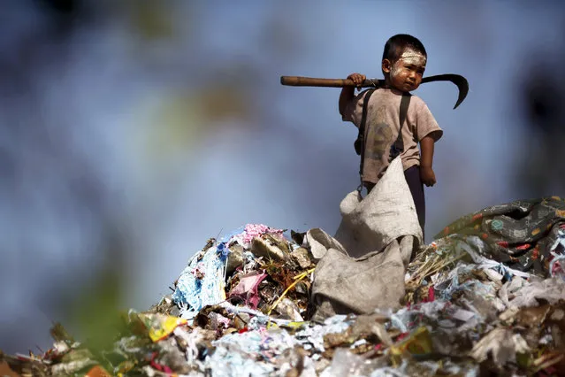An illegal immigrant boy from Myanmar collects plastic at a rubbish dump site near Mae Sot December 22, 2009. Despite terrible living conditions and the fear of being sent back to their country, several hundred illegal immigrants from Myanmar live and earn an average of $1 per day collecting plastic at the rubbish dump near the border town of Mae Sot. Myanmar's long-standing political crisis has forced millions of people to cross the border for a better and safer life. (Photo by Damir Sagolj/Reuters)