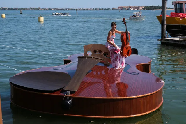 A musician plays a cello on board a boat in the shape of a violin, titled “Violin of Noah”, that was built during the pandemic by artist Livio De Marchi in collaboration with Consorzio Venezia Sviluppo and is dedicated to people who have died from coronavirus, during a test-ride, in Venice, Italy, August 6, 2021. (Photo by Manuel Silvestri/Reuters)
