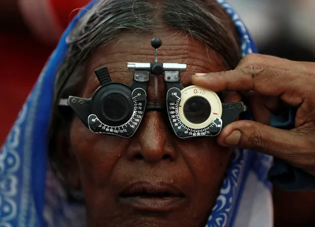 A woman gets her eyes tested at a free eye-care camp on the occasion of Indian politician Babasaheb Ambedkar's death anniversary in Mumbai, India, December 6, 2019. (Photo by Francis Mascarenhas/Reuters)