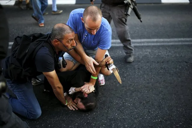 People disarm an Orthodox Jewish assailant after he stabbed and injured six participants at an annual gay pride parade in Jerusalem on Thursday, police and witnesses said July 30, 2015. REUTERS/Amir Cohen