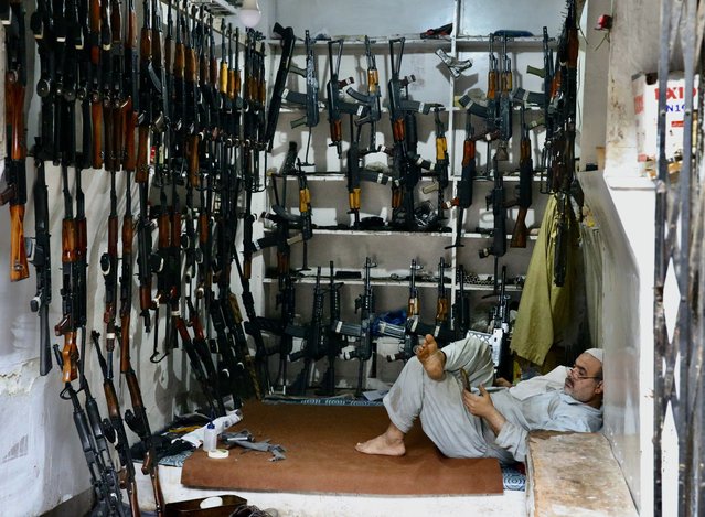 A Pakistani man and illegal weapons are seen at his gun shop in Darra Adam Khel village, in Peshawar, Pakistan on April 20, 2022. in Peshawar, Pakistan on April 20, 2022. The Pakistani city of Darra Adam Khel is the center of the illegal weapons industry in this part of the world. For 150 years, illegal weapons have been produced in homes, streets and basements. (Photo by Muhammed Semih Ugurlu/Anadolu Agency via Getty Images)
