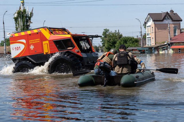 Ukrainian security forces transport local residents in a boat during an evacuation from a flooded area in Kherson on June 7, 2023, following the destruction of Kakhovka hydroelectric power plant dam. More than 2,700 people have been evacuated on both sides of the Dnipro River from flooding caused by the destruction of the Russian-occupied Kakhovka dam in Ukraine, officials said June 7, 2023. (Photo by Aleksey Filippov/AFP Photo)