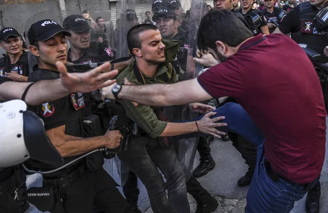 A plain-clothes police officer kicks a member of a group of LGBT rights activist as Turkish police prevent them from going ahead with a Gay Pride annual parade on June 25, 2017 in Istanbul, a day after it was banned by the city governor's office. Police fired rubber bullets at a group of around 40 activists, an AFP journalist reported, a day after the city governor's office banned the parade citing safety and public order concerns. (Photo by Bulent Kilic/AFP Photo)