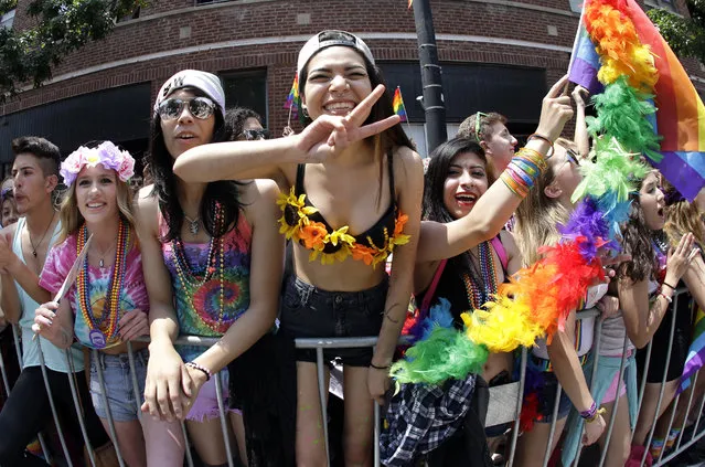 In this June 28, 2015 file photo, people smile and gesture during the annual Chicago Pride Parade in Chicago. The coordinator for Chicago's 2016 upcoming gay pride parade said Wednesday, June 15, 2016, that organizers will hire dozens more off-duty police officers than they did last year after city officials asked them to beef up security in the wake of the massacre at a gay nightclub in Florida. (Photo by Nam Y. Huh/AP Photo)