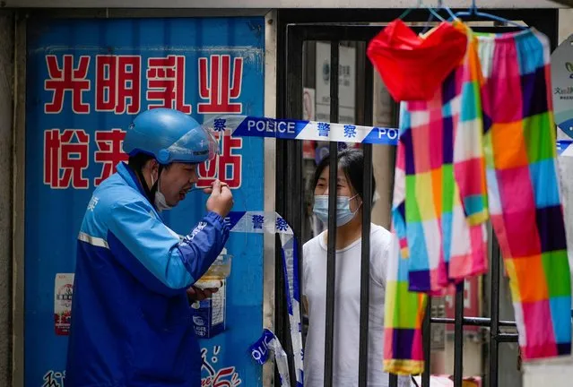 Residents chat through gaps in barriers at a closed residential area during lockdown, amid the coronavirus disease (COVID-19) outbreak, in Shanghai, China, May 27, 2022. (Photo by Aly Song/Reuters)