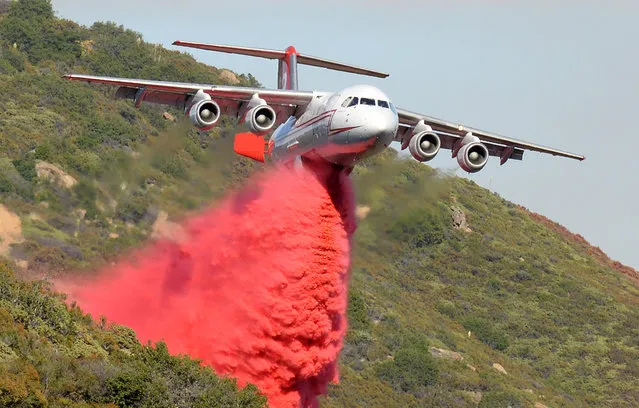 A British Aerospace BAe-146 belonging to Neptune Aviation makes a Phos-Chek drop Saturday, June 18, 2016, on wildfires in Santa Barbara County, Calif. (Photo by Mike Eliason/Santa Barbara County Fire Department via AP Photo)