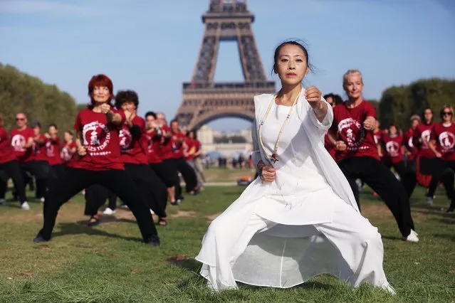 People practice Qigong, a traditional Chinese practice to cultivate and balance the body's inner energy, at Champs de Mars in Paris, France on September 14, 2019. (Photo by Gao Jing/Xinhua News Agency)