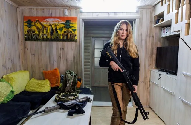 Alisa, 38, a media relations specialist, poses with a gun for a picture at her home near Kyiv, Ukraine, February 19, 2022. (Photo by Antonio Bronic/Reuters)