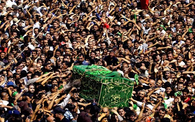 Shiite pilgrims carry a symbolic coffin at the holy shrine of the Imam Moussa al-Kadhim during the annual commemoration of the saint's death in a ceremony in Baghdad, Iraq on June 16, 2012