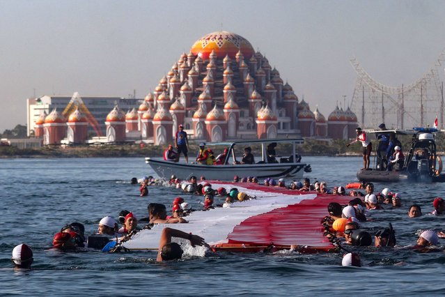 145 swimmers take part in an effort to stretch a 78-metre-long national flag in the sea ahead of Indonesia's 78th Independence Day in Makassar, South Sulawesi, on August 12, 2023. (Photo by Muchtamir Zaide/AFP Photo)