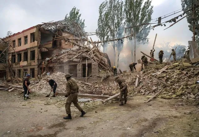 Rescuers and servicemen work at a school building damaged by a Russian military strike, amid Russia's invasion on Ukraine, in Kramatorsk, in Donetsk region, Ukraine on July 21, 2022. (Photo by Gleb Garanich/Reuters)
