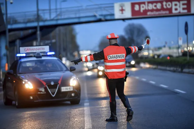 A policeman checks cars entering Milan, Northern Italy, Tuesday, March 10, 2020. People moving from one place to another must certificate they are doing it for work or important personal or health reasons, following the latest measures to slow down the diffusion of the new Coronavirus. For most people, the new coronavirus causes only mild or moderate symptoms, such as fever and cough. For some, especially older adults and people with existing health problems, it can cause more severe illness, including pneumonia. (Photo by Claudio Furlan/LaPresse via AP Photo)