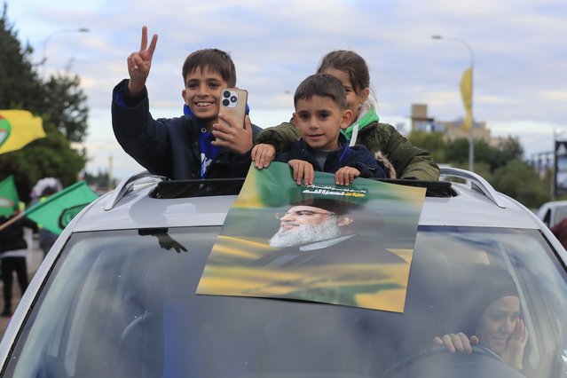Children carry a picture of slain Hezbollah leader Hassan Nasrallah as displaced residents return to their villages after a ceasefire between Israel and Hezbollah went into effect on Wednesday, November 27, 2024, in Ghazieh, Lebanon. (Photo by Mohammed Zaatari/AP Photo)