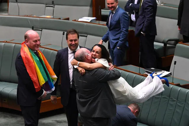 Liberal MP Warren Entsch lifts up Labor MP Linda Burney as they celebrate the passing of the Marriage Amendment Bill in the House of Representatives at Parliament House in Canberra, Thursday, December 7, 2017. (Photo by Lukas Coch/AAP Image) 