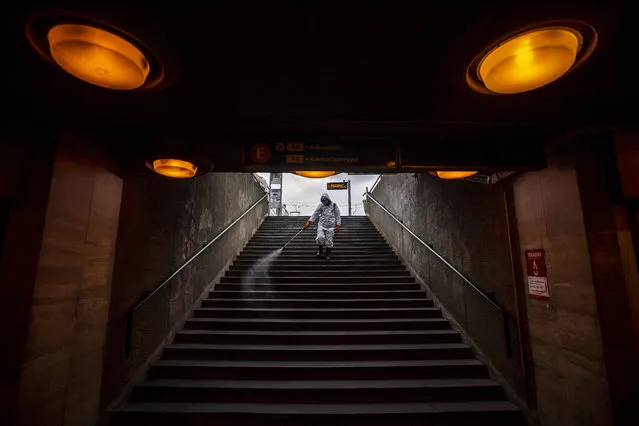 A municipal worker disinfects the subway stairs to prevent the spread of the coronavirus pandemic in Budapest, Hungary, Wednesday, March 25, 2020. (Photo by Marton Monus/MTI via AP Photo)