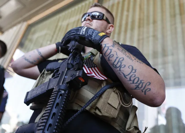 Tevor Leis, exercising his Ohio open carry rights, stands armed in Public Square on Tuesday, July 19, 2016, in Cleveland, during the second day of the Republican convention. (Photo by John Minchillo/AP Photo)