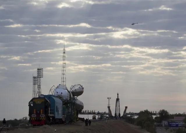 A police helicopter flies past as the Soyuz TMA-18M spacecraft is transported to its launch pad at the Baikonur cosmodrome, Kazakhstan, August 31, 2015. (Photo by Shamil Zhumatov/Reuters)