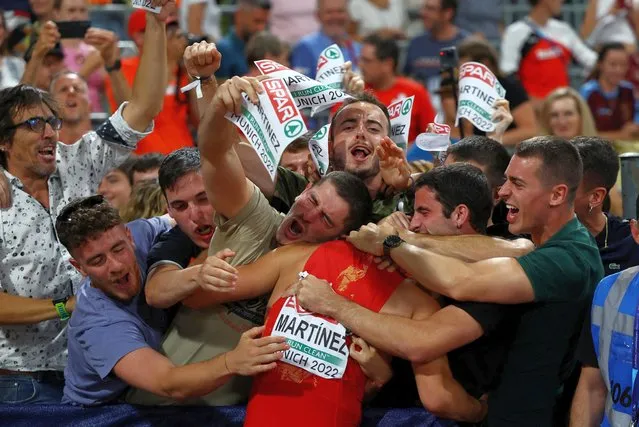 Asier Martinez, of Spain, is hugged by his supporters after winning the gold medal in the Men's 110 meters hurdles during the athletics competition in the Olympic Stadium at the European Championships in Munich, Germany, Wednesday, August 17, 2022. (Photo by Kai Pfaffenbach/Reuters)
