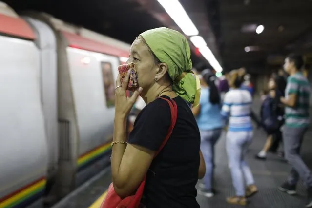 A woman covers her mouth and nose with a wash cloth on a subway platform in Caracas, Venezuela, Friday, March 13, 2020. Venezuela's Vice President Delcy Rodríguez confirmed Friday the first two cases of the new coronavirus in the South American country. The vast majority of people recover from the new virus. (Photo by Ariana Cubillos/AP Photo)