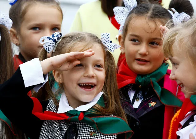 A Belarusian schoolgirl salutes during celebrations commemorating the 27th anniversary of the country's Young Pioneer movement in Minsk, Belarus September 13, 2017. Early pro-communist pioneer movements appeared in Russia after the 1917 Bolshevik revolution and in May 1922, they were organised into the Young Pioneer Organisation of the Soviet Union with units active in all republics of the union. In Belarus, the Young Pioneers remains a government-loyal youth movement. (Photo by Vasily Fedosenko/Reuters)