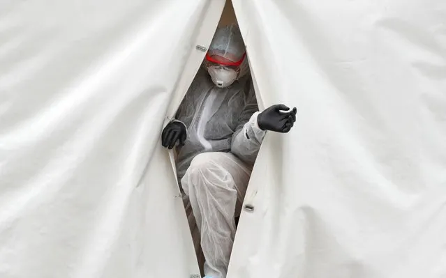 A medical specialist walks out of a mobile laboratory, which carries out tests to detect the coronavirus disease (COVID-19) near the Moscow International Business Centre, also known as “Moskva-City”, in Moscow, Russia on April 27, 2020. (Photo by Evgenia Novozhenina/Reuters)